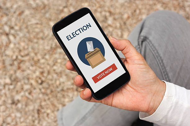 istock Hand holding smart phone with online voting concept on screen 537356322