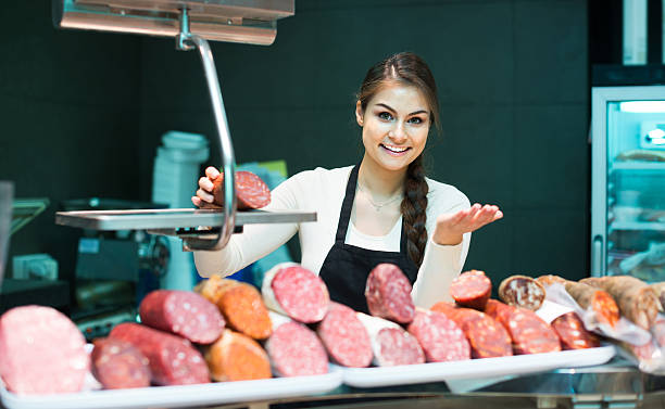 kobieta rzeźnik z mięsa i wurst i bolonia w kasie sklepu - butchers shop meat sausage store zdjęcia i obrazy z banku zdjęć