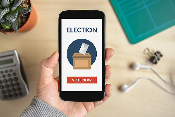 istock Hand holding smart phone with online voting concept on screen 537356504