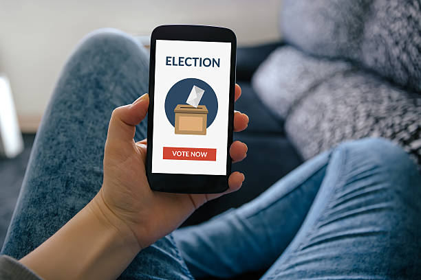 Hand holding smart phone with online voting concept on screen stock photo