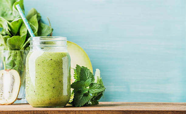 istock Freshly blended green fruit smoothie in glass jar with straw 537357354