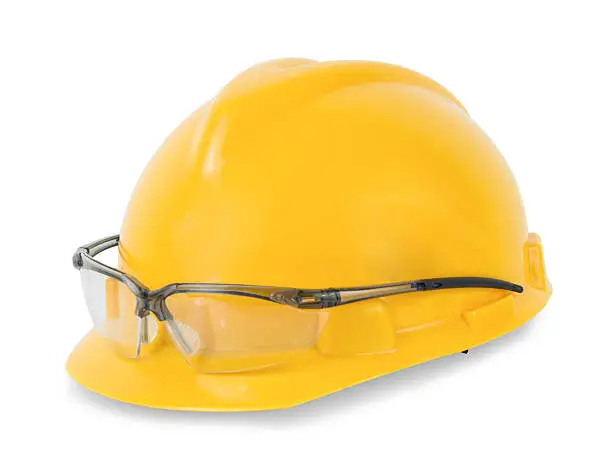 Photo of Yellow safety helmet and goggles  isolated on white background