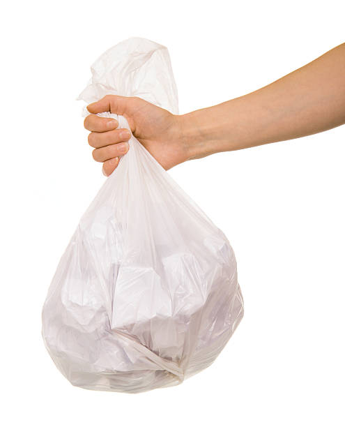 istock Transparent plastic bag with paper waste in  female hand isolated. 537360414