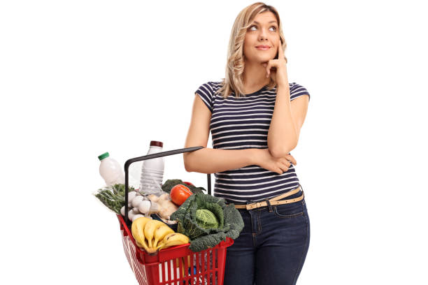 Pensive young woman holding a shopping basket isolated on white background