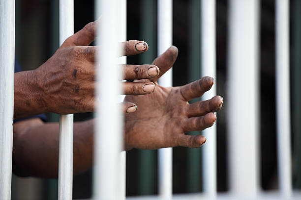 istock hands of prisoner in jail. 537365344