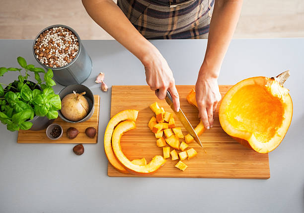 closeup on young housewife cutting pumpkin