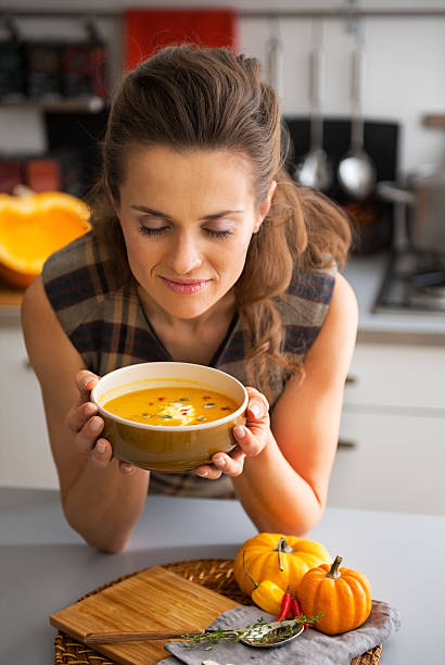 istock young woman enjoying pumpkin soup in kitchen 537367911