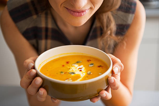 istock closeup on young woman enjoying pumpkin soup 537367945