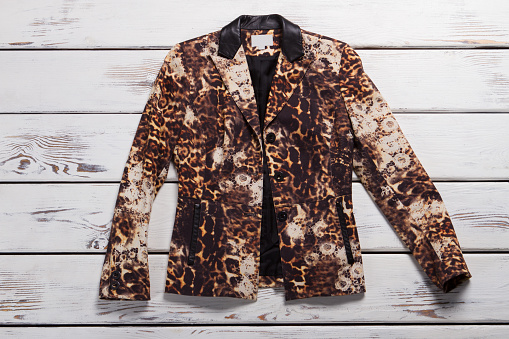 Girl's leopard blazer. Leopard blazer on wooden background. Exclusive garment from boutique. Luxury and originality.