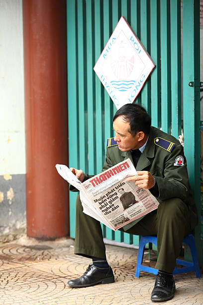 vietnam policía leer un periódico - mature adult male men portrait fotografías e imágenes de stock