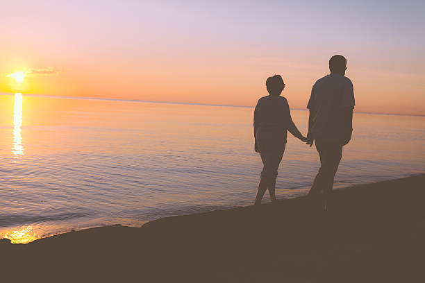 istock Senior couple walking along the beach 537369401