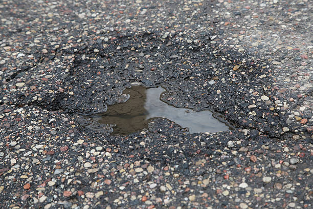 istock The pit on the asphalt road with puddle 537370669