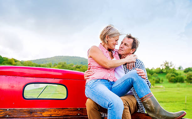 istock Senior couple sitting in back of red pickup truck 537370708