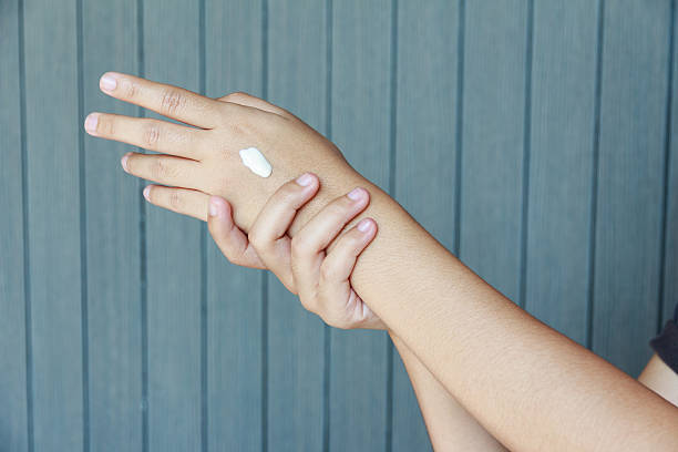 istock Young woman applying hands cream in her room 537372646