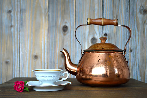 Old copper teapot and porcelain teacup