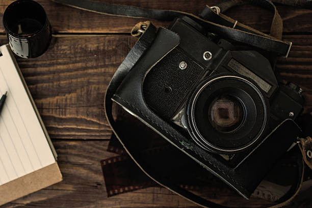 istock old retro camera with photo film rolls, notebook and pen 537373396