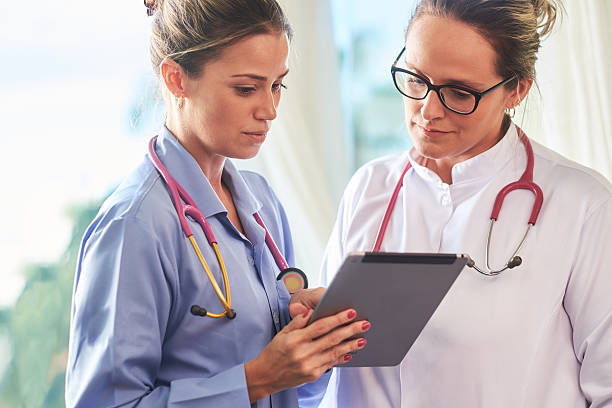 Young brazilian doctor and nurse with tablet Young brazilian doctor and nurse checking patient information on a tablet device doctor utensils stock pictures, royalty-free photos & images