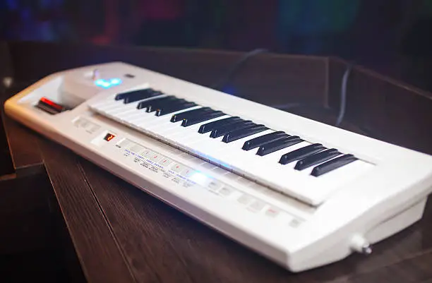 Photo of White synthesizer with black buttons on the table