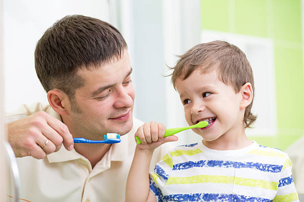 istock father and kid son brushing teeth in bathroom 537376418