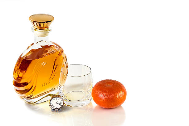 bottiglia e bicchiere di whisky vuote su sfondo bianco con mandarino - gin decanter whisky bottle foto e immagini stock