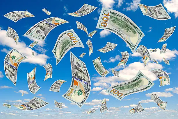 Hundred-dollar bills flying in the sky.