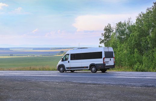 minibus goes on the country highway along the wood