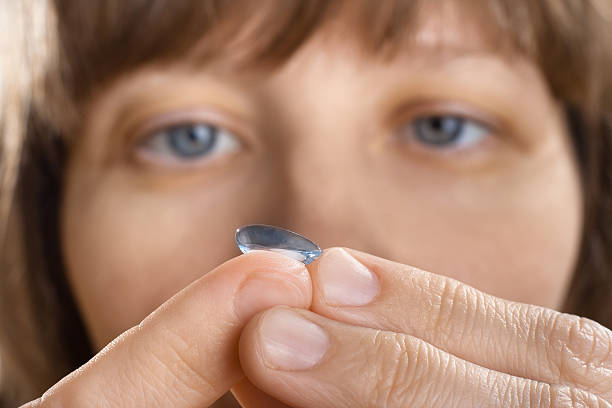 istock woman putting contact lens (selective focus used) 537383462
