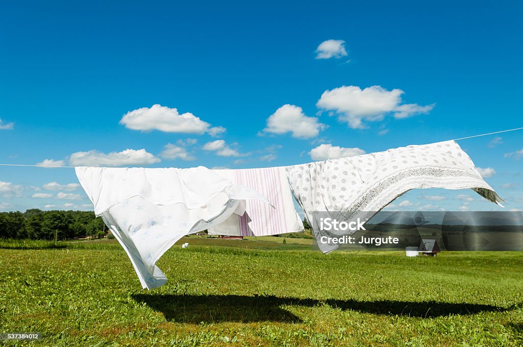Laundry drying in a wind, white sheets on a wind in nature background  Laundry drying in a wind, white sheets on a wind in nature background, housework concept Laundry Stock Photo