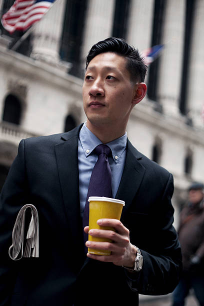 Asian Man in Financial District in New York City Asian Man in Financial District in New York City. newpapers stock pictures, royalty-free photos & images