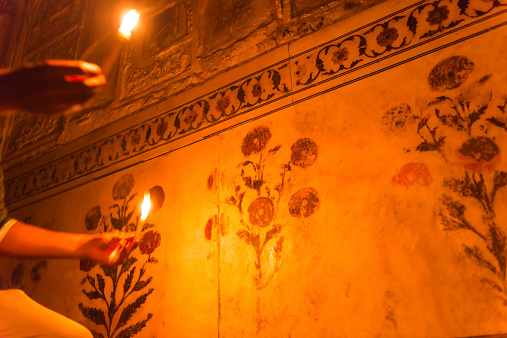 Inside the Musamman Burj (Jasmine Tower, Jasmine palace),Agra fort, Agra,INDIA. Where the place that emperor Shah Jahan who built Taj Mahal was imprisoned by his son and died here. Very nicely carved and painted wall, flower pattern, two hands holding a candle that illuminate the wall. 