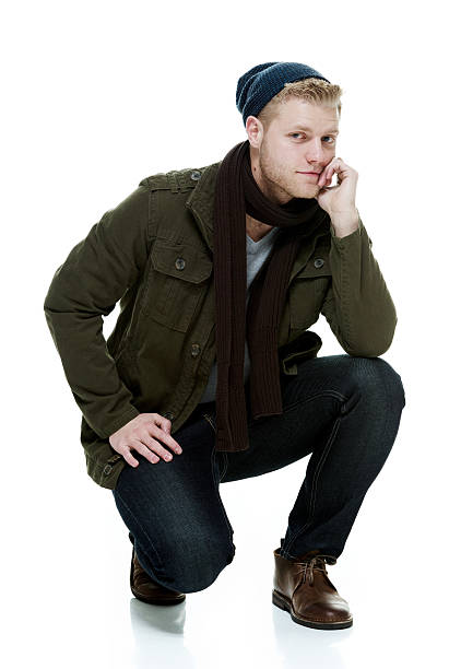 istock Man in winter clothes crouching & looking at camera 537390011