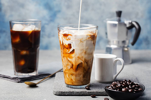 istock Ice coffee in a tall glass with cream poured over 537391120