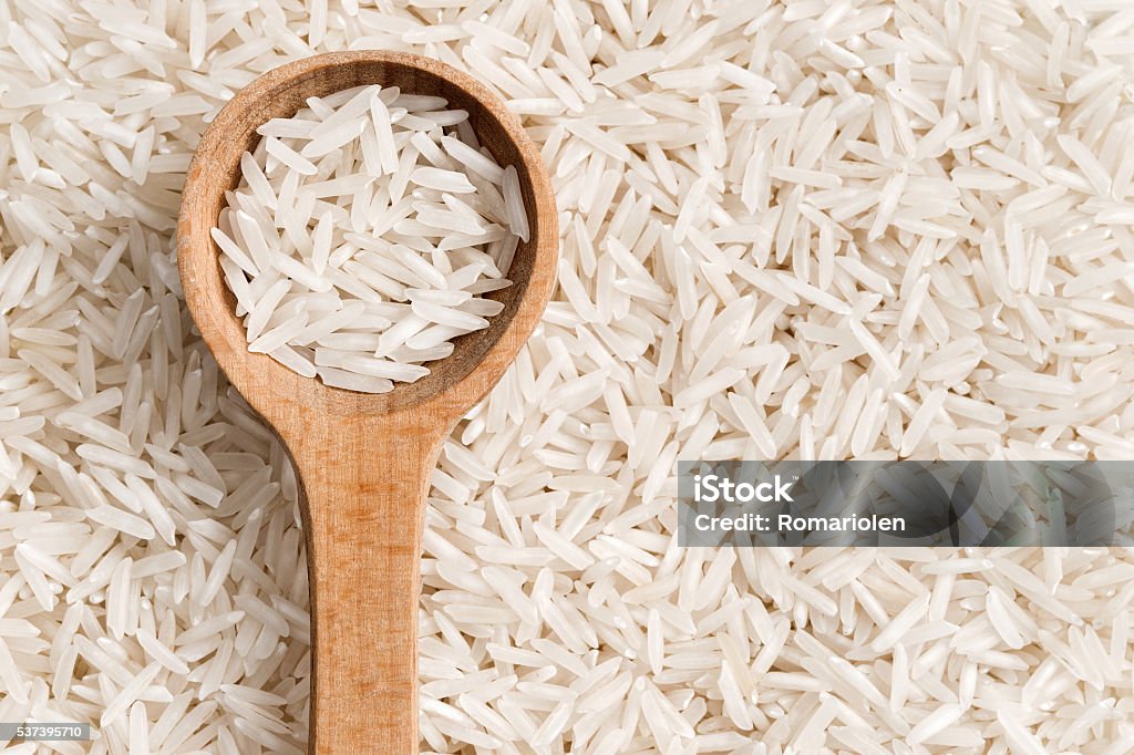 Rice on a wooden spoon. Rice on a wooden spoon. Close up, top view, high resolution product. Basmati Rice Stock Photo