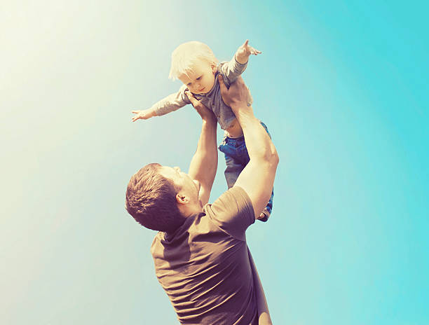 istock Happy father and son playing having fun outdoors over sky 537396182