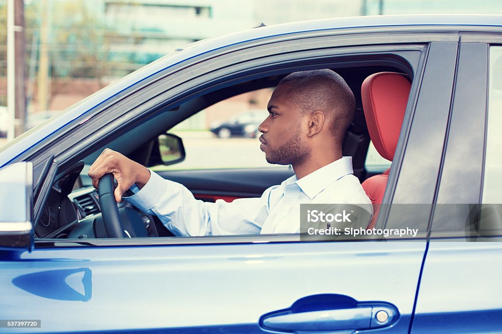 young man driving his new car Closeup portrait young man driving his new car. Personal transportation auto purchase safety concept Car Stock Photo