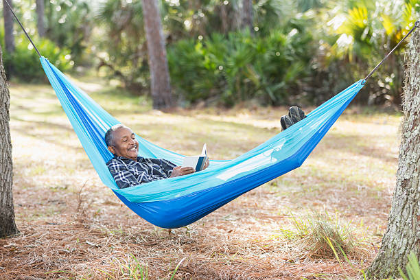 istock Senior African American man in hammock reading book 537398786