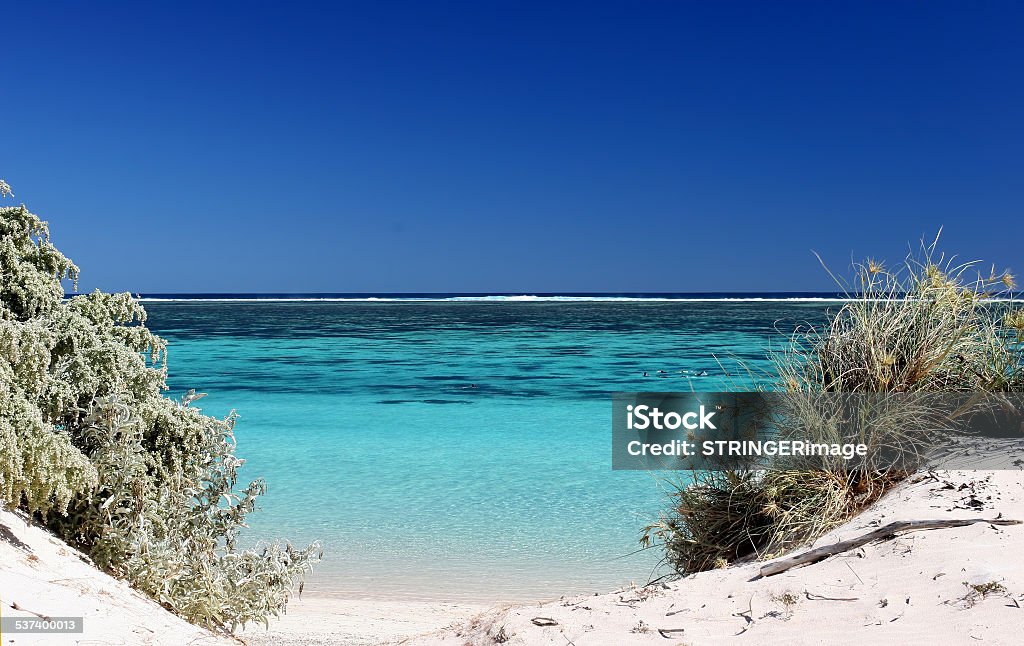 Ningaloo Beach and Reef View of the pristine turquois waters through gap in the dunes at Ningaloo reef Western Australia Ningaloo Reef Stock Photo