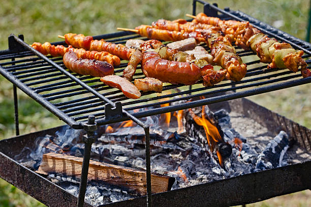 Meat cooking on a wood-fired barbecue in a garden, a daily pleasure for the summer season which is just beginning