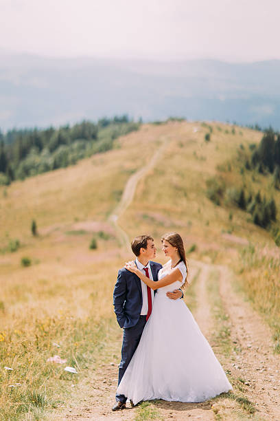 istock Romantic couple posing on trail across yellow sunny field with 537402960