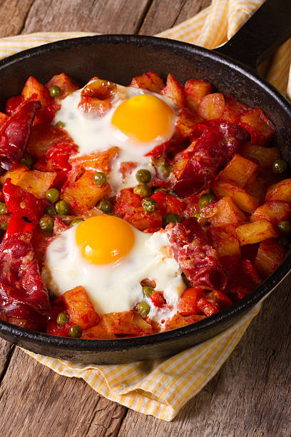 istock Fried eggs with chorizo and vegetables in the pan. Vertical 537403293