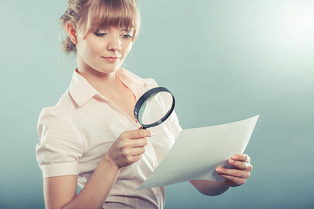istock woman uses magnifying glass to check contract 537404032