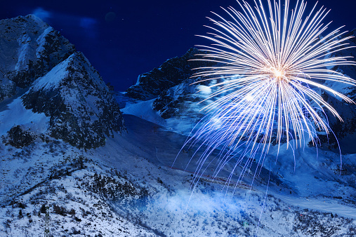 Brightly colorful fireworks. Night skiing.  Panoramic view of  high mountain winter landscape Passo Tonale ski area. Passo del Tonale is a wide, panoramic, natural amphitheatre lying between 1,884 and 3,100 metres above sea level.  The grain and texture added.