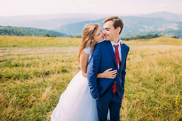 istock Young wedding couple posing on sunny field with distant forest 537404616