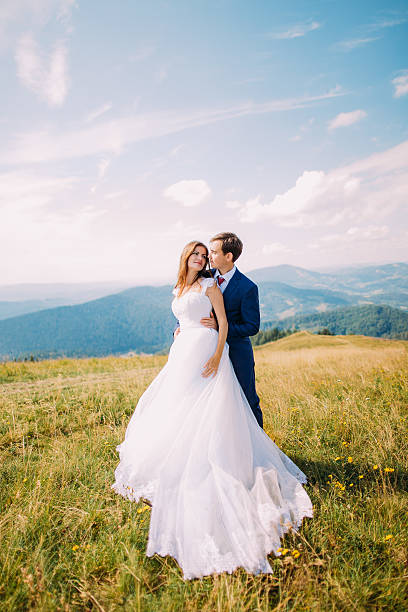 istock Young romantic wedding couple posing on sunny grass field with 537404696