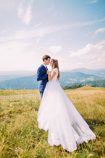 istock Romantic newlywed bride and groom posing on sunny grass field 537404722