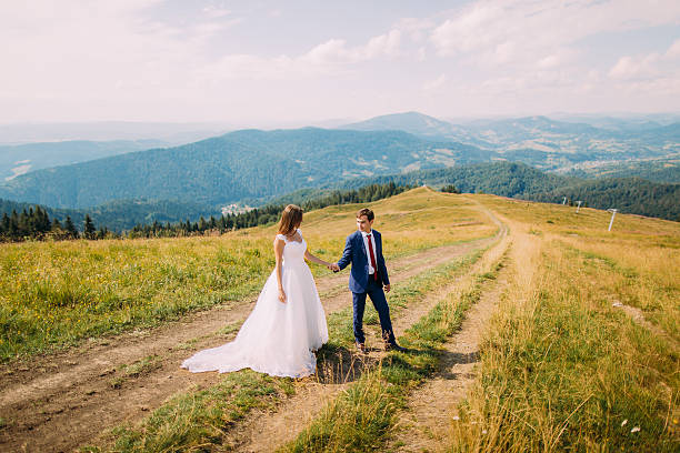 istock Newlyweds - handsome groom and gorgeous bride walking on trail 537404884