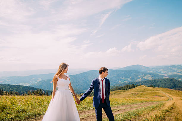 istock Romantic couple strolling on trail across yellow sunny field with 537404970