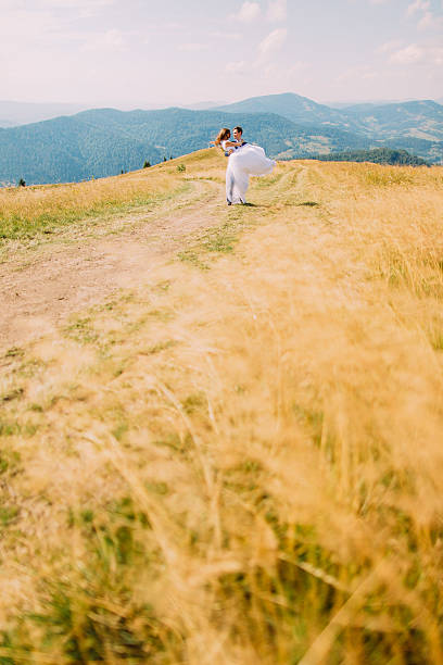 istock Young romantic wedding couple posing on windy golden sunny field 537405208