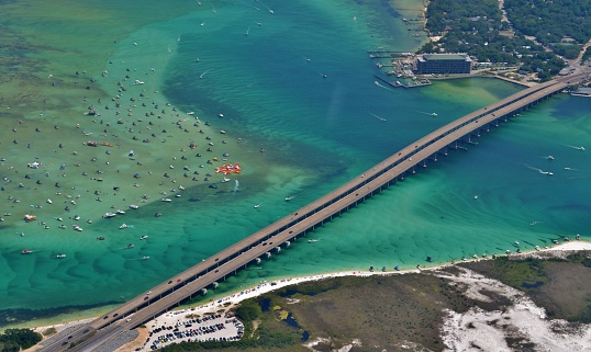 Aerial image of the Destin Harbor in Destin, FL, showing the East Pass, Crab Island, and the Marler Bridge.