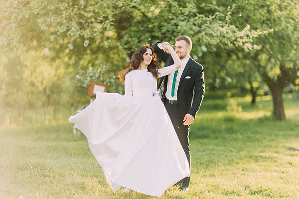 istock Happy newlyweds dancing on grass in park with their bicycle 537410648